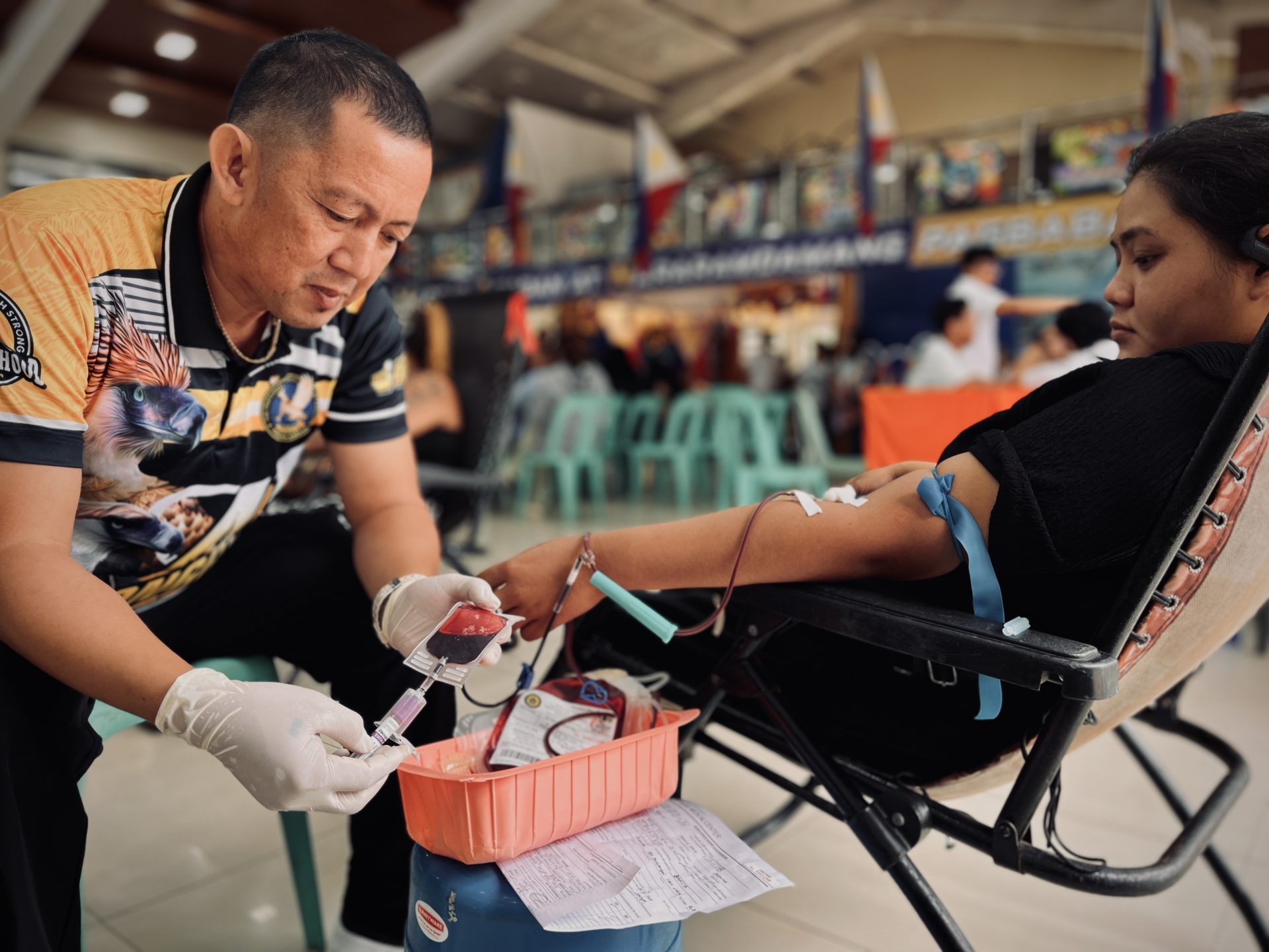 A blood donor attended by a member of the donation team during a community blood donation activity