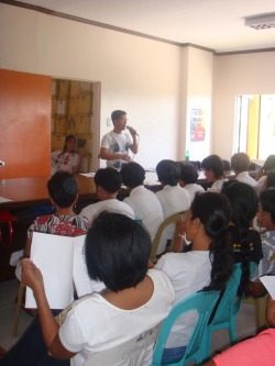A community information session with an audience seated inside a local venue